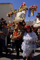 People carrying cross and in traditional dress at Saintes Maries de la mer gipsy festival, May, Camargue, France 2006