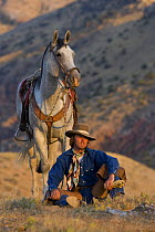 Cowboy sitting relaxing with horse, Shell, Wyoming, USA
