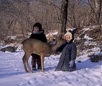Children with tame Roe deer {Capreolus capreolus} "Kedrovaya Pad" Zapovednik / Reserve, Ussuriland, Primorsky, SE Siberia, far east Russia