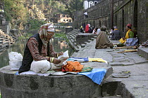 Man reading beside Pashupatinath temple, Kathmandu, Nepal