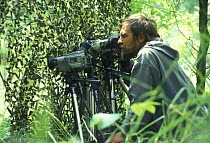 Wildlife photographer, Yuri Shibnev, with camouflage netting, Siberia, Russia