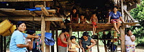 Embera Indian women and children in traditional thatched house. Mouge village, Darien Province, Panama, Central America 2006