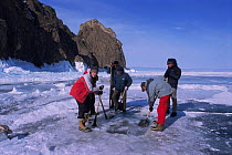 Film crew digging hole in ice for cameramen to dive in Lake Baikal, world's deepest and oldest (and largest by volume) freshwater lake, Siberia, Russia on location for BBC Planet Earth series, April...