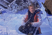 Mark Brownlow, producer of Freshwater programme for BBC Planet Earth series, behind ice sheet, on location at Lake Baikal, world's deepest and oldest (and largest by volume) freshwater lake, Siberia,...