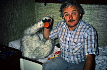 Martin Saunders, cameraman, with joke swan in boat cabin, filming for BBC 'The First Eden' 1985