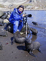 Photographer Sue Flood taking pictures of young Antarctic fur seals (Arctocephalus gazella) in Antarctic peninsula on location for BBC Planet Earth, January 2005.