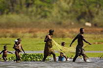 Family fishing with net in Lake Ravelobe across from the Ampijeroa Forest Station. Ankarafantsika Nature Reserve, Western deciduous forest. MADAGASCAR   2005