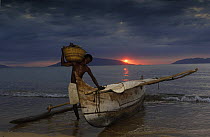 Fisherman returns from night fishing in Piroque or outrigger canoe, Ampasendava Village. North eastern MADAGASCAR 2005