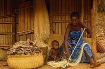 Sakalava woman working with Raffia from the Raffia palm (Raffia rarinifera) Ankarafantsika Nature Reserve, Western deciduous forest. MADAGASCAR 2005