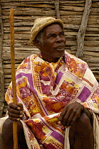 Antandroy man wearing hat made from the pith of cactus pads, sitting outside traditional house made from Didiereacaea plants. Spiny forests of Southern Madagascar  2005