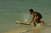Vezo child playing on the beach with model pirogue. Beheloka Vezo fishing village. South-western MADAGASCAR 2005