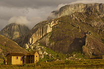 Betsileo house near Ambalavao town. South-central highlands of MADAGASCAR. Granite cliffs in background