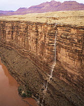 Water from flash floods cascades down Marble Canyon into the Colorado River, Grand Canyon NP, Arizona, USA
