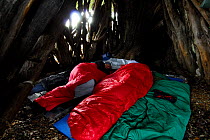 People in sleeping bags resting during day, in traditional sardinian goat hut, Sardinia, Italy