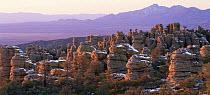 Spires of Chiricahua National Monument sprinkled with early snow, double summit of Dos Cabezas Mt and Sulphur Springs Valley in background, Arizona, USA