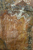 Rock art, Kakadu National Park, Northern Territory, Australia - Barrginj, wife of Namarrgon the lightening man, sits above a family group of men and their wives on their way to a ceremony.