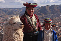 Indian woman and boy in traditional dress with llama (Lama glama) Cusco, Peru 2006.