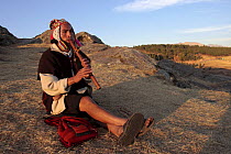 Local indian playing the quena flute in the ruins of Sacsayhuaman, Cusco, Peru 2006.