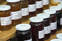 Jars of home made jams and preserves for sale at a farmers market, Norfolk, UK