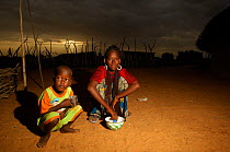 Fulani teenage girl looking after her young brother, sunrise, North Senegal, West Africa, 2005