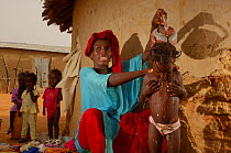 Fulani woman washing her child in refugee camp, Senegal, 2005
