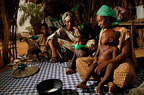 Fulani woman feeding her grandchildren with milk, north Senegal, West Africa, 2005