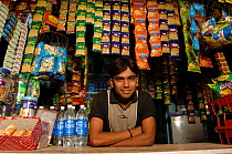 Man selling snacks over counter, India 2006