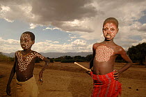 Two young Erbore boys show their body paints, these are usually only applied for special celebrations, Omo valley, Ethiopia, 2006