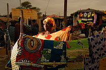 Fulani woman selling colourful material and handicraft at the market, North Senegal, West Africa, 2005