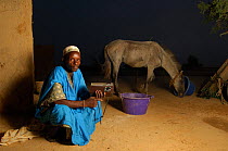 Fulani man listening to radio with horse in background, South Mauritania, West Africa, 2005