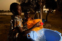 Young Fulani women drawing water from a well shaft built by the United Nations High Commision for Refugees, North Senegal, West Africa, 2005