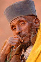 Christian worshipper near St Sauveur's church, Lalibela, North Ethiopia. These worshippers stay for hours in a hole in the carved rock to read their holy books, 2006