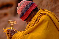 Christian worshipper near St Sauveur's church, Lalibela, North Ethiopia. These worshippers stay for hours in a hole in the carved rock to read their holy books., 2006