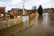 Flood barrier keeps flood water from construction site of new buildings beside flooded River Severn, Shrewsbury, Shropshire, UK, winter 2006/7