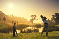 Couple playing an early morning round of Golf, Cheshire, England, UK