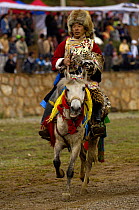 Horse {Equus caballus} and rider wearing endangered leopard skin furs at the Horse Racing Festival or 'Heavenly Steed Festival' which takes place on the 5th and 6th days of the fifth lunar month. Zhon...