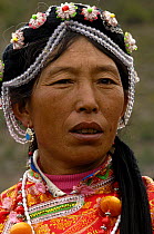 Mosuo (or Moso) woman in traditional dress at the Horse Racing Festival or 'Heavenly Steed Festival' which takes place on the 5th and 6th days of the fifth lunar month. Zhongdian, Deqin Tibetan Autony...
