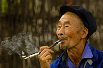 Lisu man smoking pipe, Jianchuan County, bordering Lijiang, Yunnan Province, China 2006
