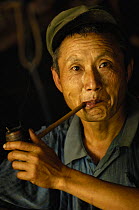 Black Lisu ethnic minority man smoking wooden home-made pipe near Fulong, Nujiang Prefecture, Yunnan Province, China 2006