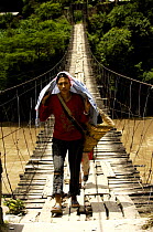 Woman walking along a suspension bridge on the Nu River, Gongshan County, Yunnan Province, China 2006