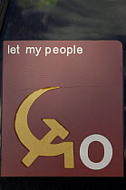 Let my People Go sign - political propoganda incorporating Communist hammer and sickle symbol,  China 2006