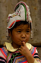 Yi girl with 'rooster' hat worn for protection, Yuanyang, Honghe Prefecture, Yunnan Province, China 2006