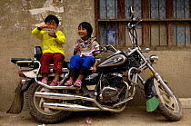 Yi children sitting on motor bike, Yuanyang, Honghe Prefecture, Yunnan Province, China 2006