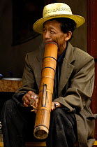 Man smoking a through a bong pipe, Yunnan Province, China 2006