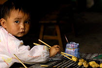 Chinese child eating with chopsticks, Yunnan Province, China 2006
