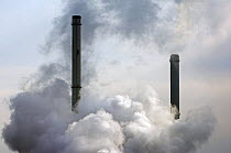 Pollution from petrochemical industry showing chimneys encompassed with smoke, Antwerp harbour, Belgium