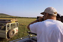 Camerman Gavin Thurston filming Cheetah on top of vehicle for BBC NHU 'Big Cat Diary', Masai Mara GR, Kenya