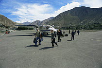 Film crew for BBC NHU 'Planet Earth - Mountains' arrive at Jomosom airstrip, Himalayas, Nepal, c 2004