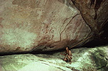 Medicine man at Piaroa funderal cave, with ancient cave paintings, Venezuela