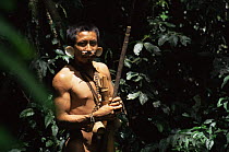 Matis Indian man hunting in the rainforest with blowpipe and poison tip arrows, Amazonia, Brazil.  Facial decorations are thought to mimic jaguars.